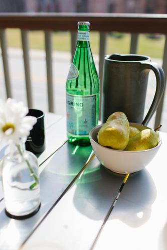 The Porches Inn at Mass MoCA في نورث آدمز: وعاء من الفواكه على طاولة بجوار زجاجة