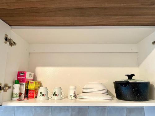 a shelf in a kitchen with dishes and a pot at Tu Oasis en el Centro in Santa Cruz de la Sierra