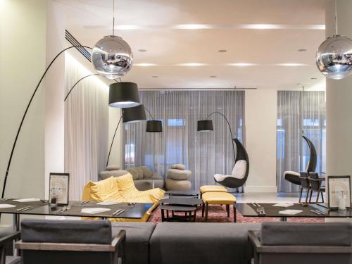 a living room with a couch and chairs at Novotel London Brentford in Brentford
