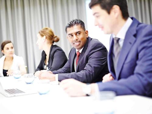 a group of people sitting at a table in a meeting at Novotel London Brentford in Brentford
