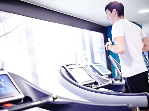 a man running on a treadmill in a gym at Novotel London Brentford in Brentford