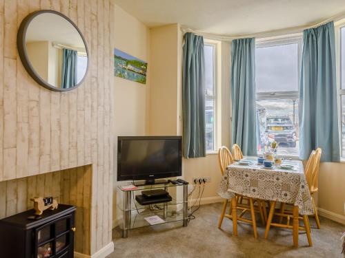 a living room with a television and a table with chairs at Hodges - Uk30761 in Gorleston-on-Sea