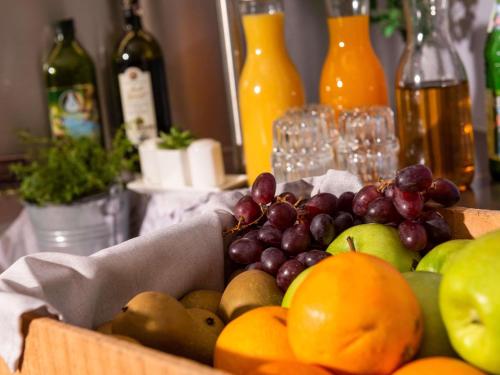 a basket of fruit on a table with wine bottles at ibis Kassel Melsungen in Melsungen