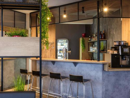 a bar with black stools in a restaurant at ibis Kassel Melsungen in Melsungen