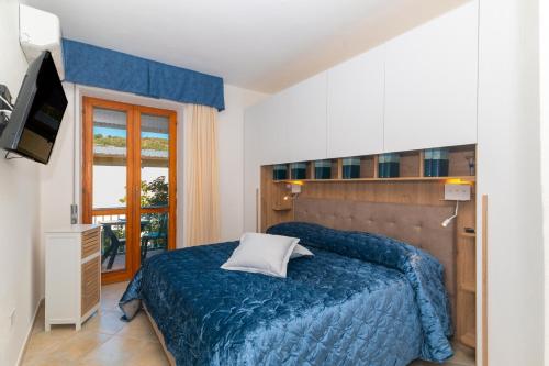 a bedroom with a blue bed and a television at La Casa in Gallura in Calangianus
