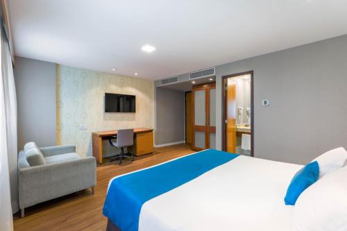 a hotel room with a bed and a desk at Wyndham Sao Paulo Ibirapuera Convention Plaza in Sao Paulo