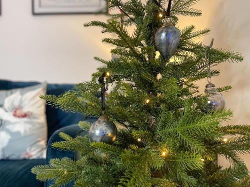 a christmas tree with silver ornaments on it at Forest Acorn in Brockenhurst