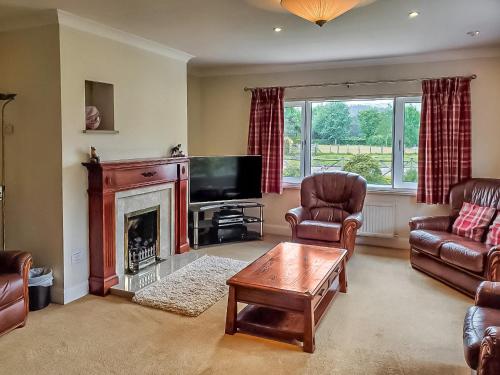 a living room with a fireplace and a tv at Crossfeld in Keswick