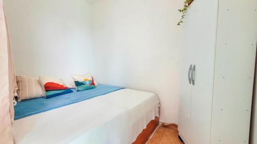 a white bedroom with a bed with pillows on it at Casa Mar e Mar in Cabo Frio