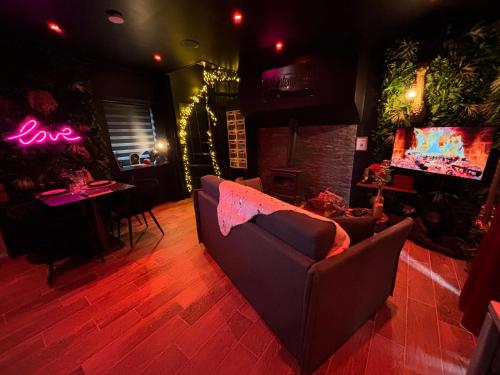 a living room with a couch and a table with a tv at La Sainteny Touch in Sainteny