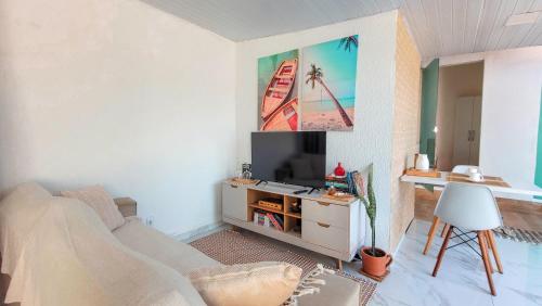 a living room with a couch and a tv at Casa Mar e Mar in Cabo Frio