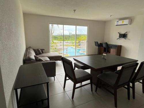 a living room with a table and chairs and a couch at Lyra Vacacional Acapulco in Acapulco