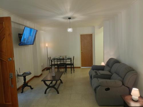 a living room with a couch and a table at Apartamento Renovado en el Centro de Caracas Cerca de Todo in Caracas