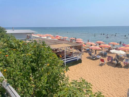 a beach with umbrellas and people in the water at B&B Capo Rizzuto Armenes in Capo Rizzuto