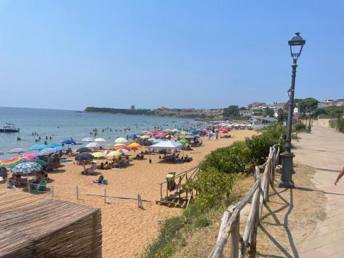 a beach with many umbrellas and people on the beach at B&B Capo Rizzuto Armenes in Capo Rizzuto