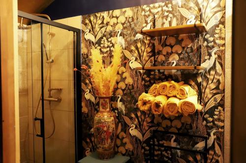 a bathroom with a vase and flowers on a wall at Domek Wróżki - Sanktuarium Laparica w Puszczy Białej 