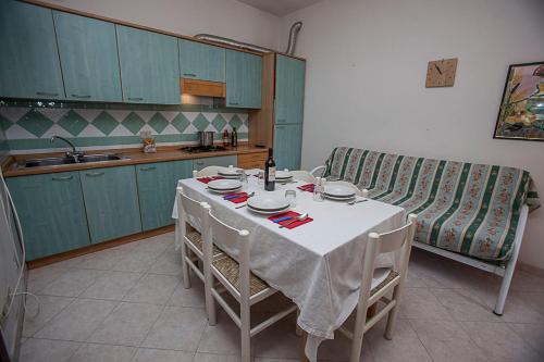 cocina con mesa con sillas y sofá en Cozy apartment near the beach, en Rosolina Mare