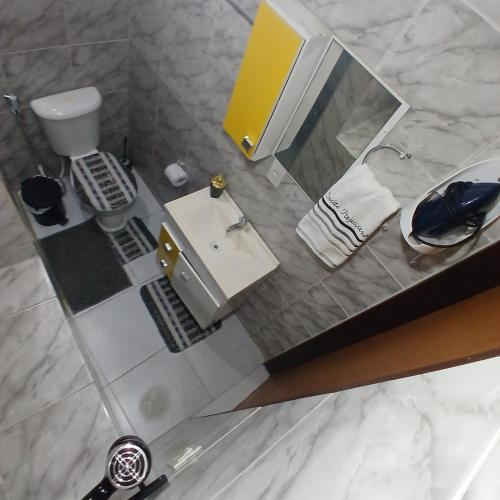 a small bathroom with a sink and a mirror at Suite Pajuçara in Maceió