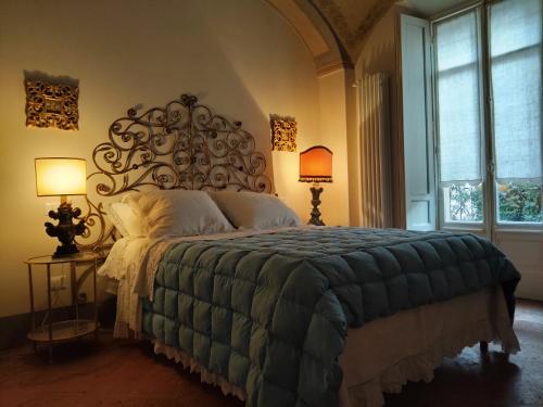 a bedroom with a large bed and two lamps at Le Melusine Appartamento Grazia in Vercelli