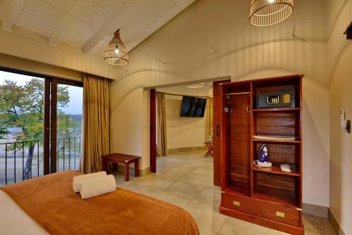 a bedroom with a large bed and a balcony at Hwange Safari Lodge in Dete