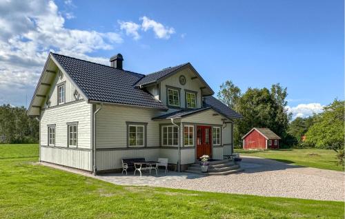 a white house with a red door and a lawn at Pet Friendly Home In Bolmsö With Sauna in Bolmsö