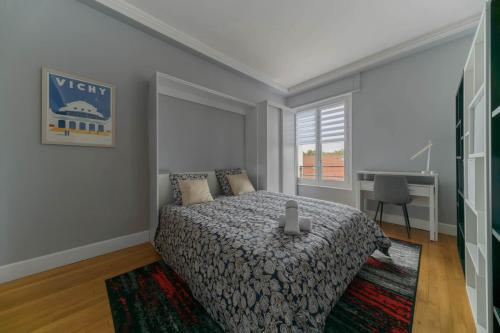 a bedroom with a bed and a desk in it at Le Sainte Barbe - Hyper Centre - Parc des sources in Vichy