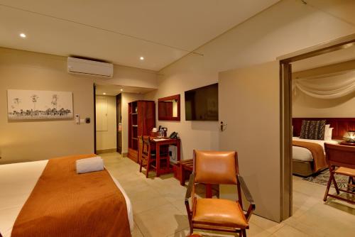 a hotel room with a large bed and a desk at Hwange Safari Lodge in Dete