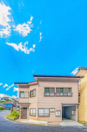 an apartment building with a blue sky in the background at Yunosawa HOUSE in Kusatsu