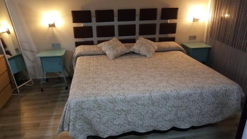 a bedroom with a bed with two tables and two lamps at Alojamiento Nohal in La Iruela