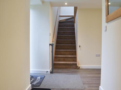 a hallway with a staircase with a carpet at North Barn in Monk Okehampton