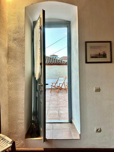 a door to a balcony with a view of the water at Kaminēa in Hydra