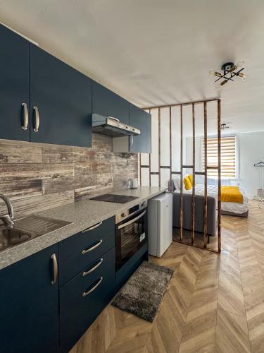a blue kitchen with a sink and a refrigerator at Tottenham City Stays, Opposite Seven Sisters Train Station in London