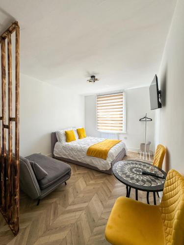 a bedroom with two beds and a table and a couch at Tottenham City Stays, Opposite Seven Sisters Train Station in London