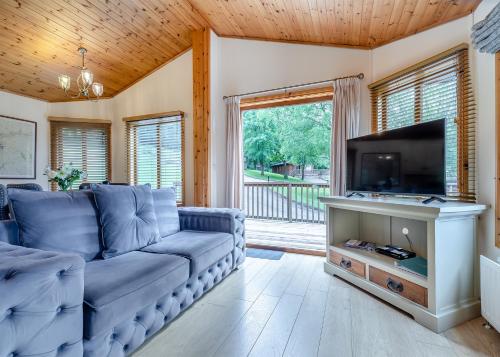 a living room with a couch and a flat screen tv at Charlesworth Lodges in Glossop