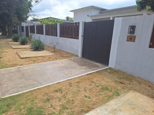 a fence in a yard next to a house at Toti guest house 5 in São Tomé