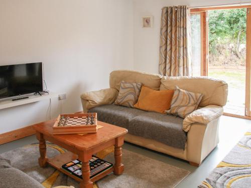 a living room with a couch and a table at Haycart Barn in Long Stratton