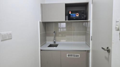 a kitchen with a sink and a microwave at Trion Skyline Luxury Residences in Kuala Lumpur
