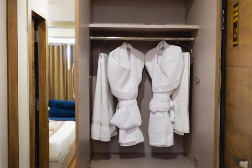 a group of white towels hanging in a closet at INDUS TIARA- A Corporate Boutique Hotel in Siliguri