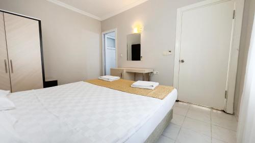 a white bedroom with a large bed and a mirror at Side Beach Club in Side