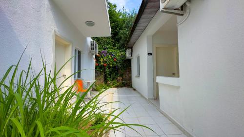an alley with plants and a white building at Side Beach Club in Side