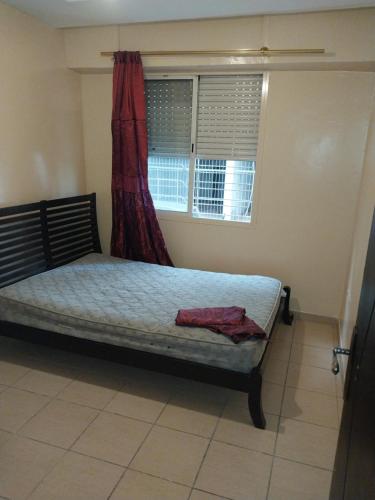 Zemmour TouirzaにあるAppartement disponibleのベッドルーム1室(赤いカーテン付きのベッド1台付)