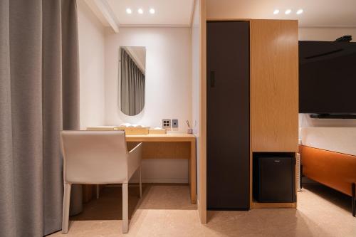 a room with a desk and a bed and a bedroom at Browndot Incheon Airport New City in Incheon