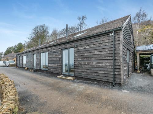 a wooden building with windows on the side of a road at Kinder in Mellor