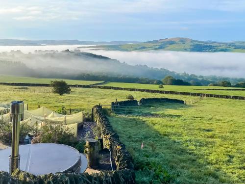 a view of a field with fog in the distance at Kinder in Mellor