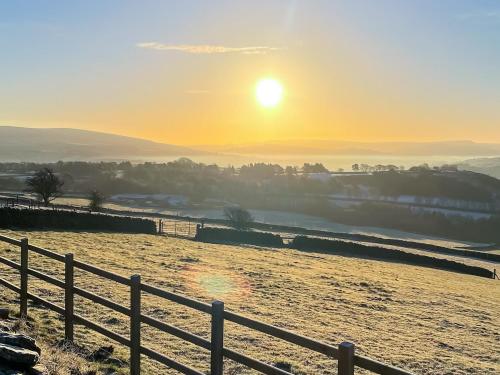 a field with the sun setting in the background at Kinder in Mellor