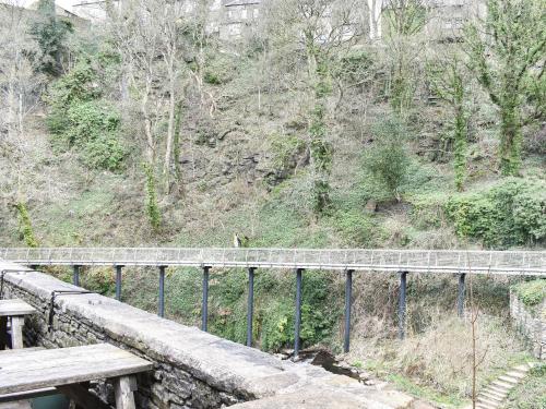 a bridge over a hill with benches and trees at Kinder in Mellor