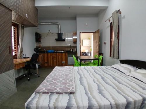 バンガロールにあるStudio Room in Bengaluruのベッドルーム1室(大型ベッド1台、デスク、テーブル付)