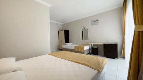 a hotel room with two beds and a desk at Side Beach Club in Side