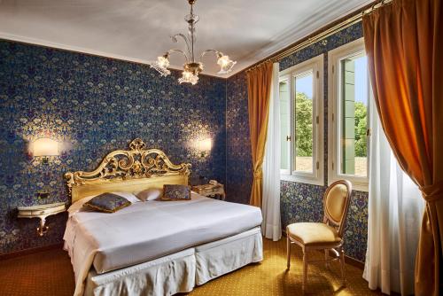 a bedroom with a bed and a chandelier at Hotel Gardena in Venice