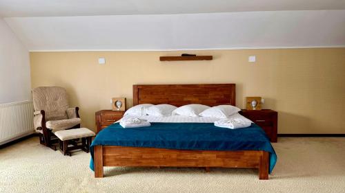 a bedroom with a large bed and a chair at Conacul Dascălu in Trăisteni